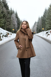 a lady in a tencel wool brown coat and a pair of black pants